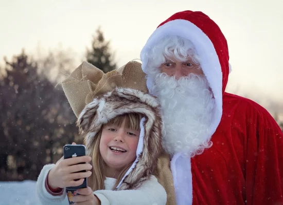 Dziewczynka robiąca zdjęcie z Mikołajem