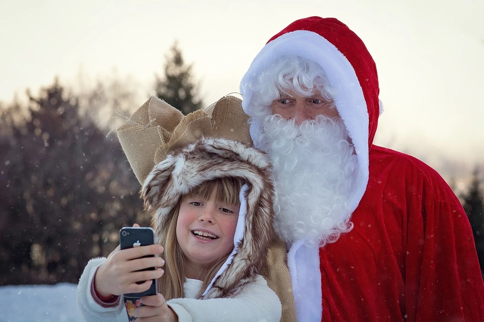 Dziewczynka robiąca zdjęcie z Mikołajem